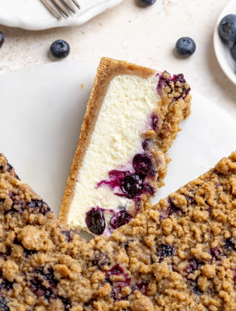 Cheesecake con crumble di mirtilli su piatto decorativo